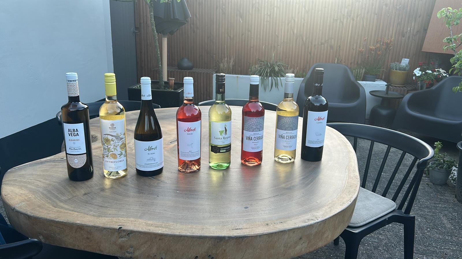 Een rij flessen klaargezet op een houten tafel